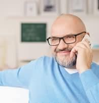 12 Ways to Protect Your Mobile Device A man wearing sweatshirt calling in his phone.