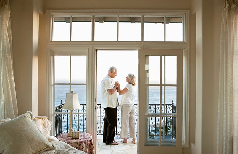 Your Family’s Real Estate is Too Important to Trust to Any Trustee An elegant shot of a man and a woman on the balcony.