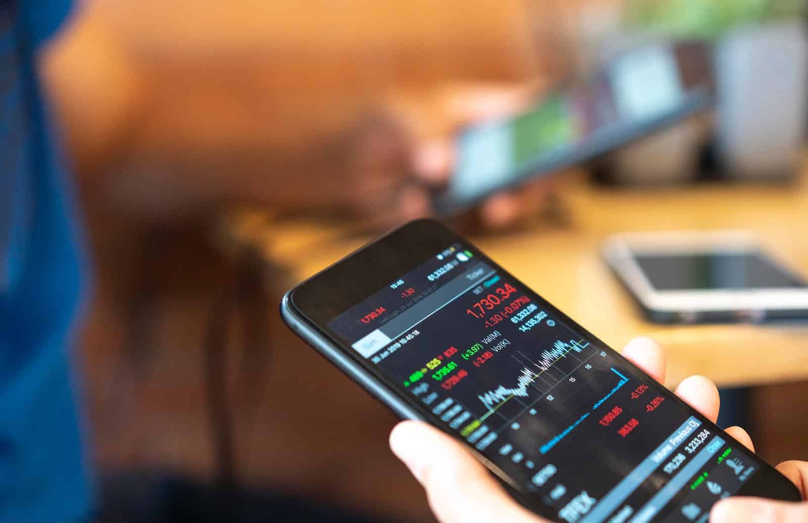 Why Investors Are Recalibrating Their Portfolio Right Now A close up shot of a person's handling a phone.
