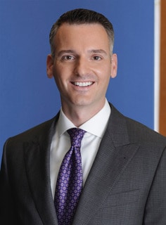 A professional headshot of Nickolaus P. Momyer.