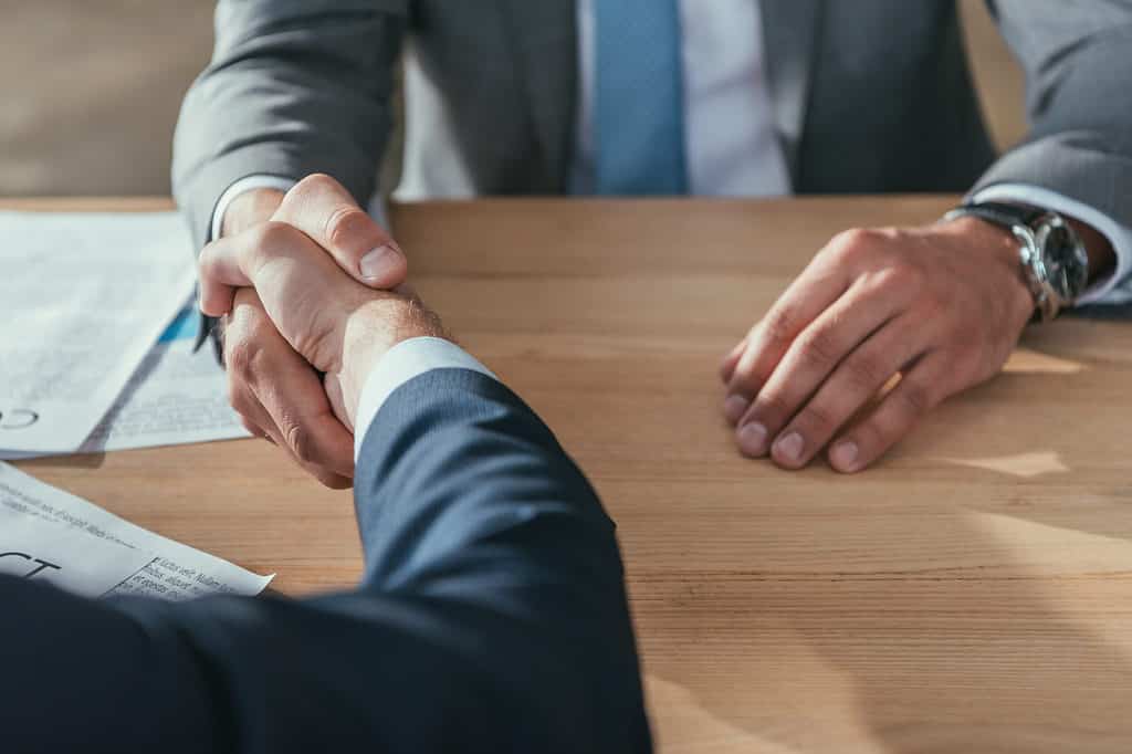 Close-up of business people shaking hands to confirm their partnership.
