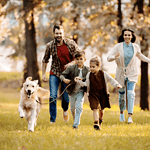 Family running in field with dog