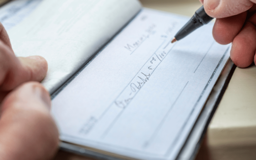 writing check for charity giving after a liquidity event